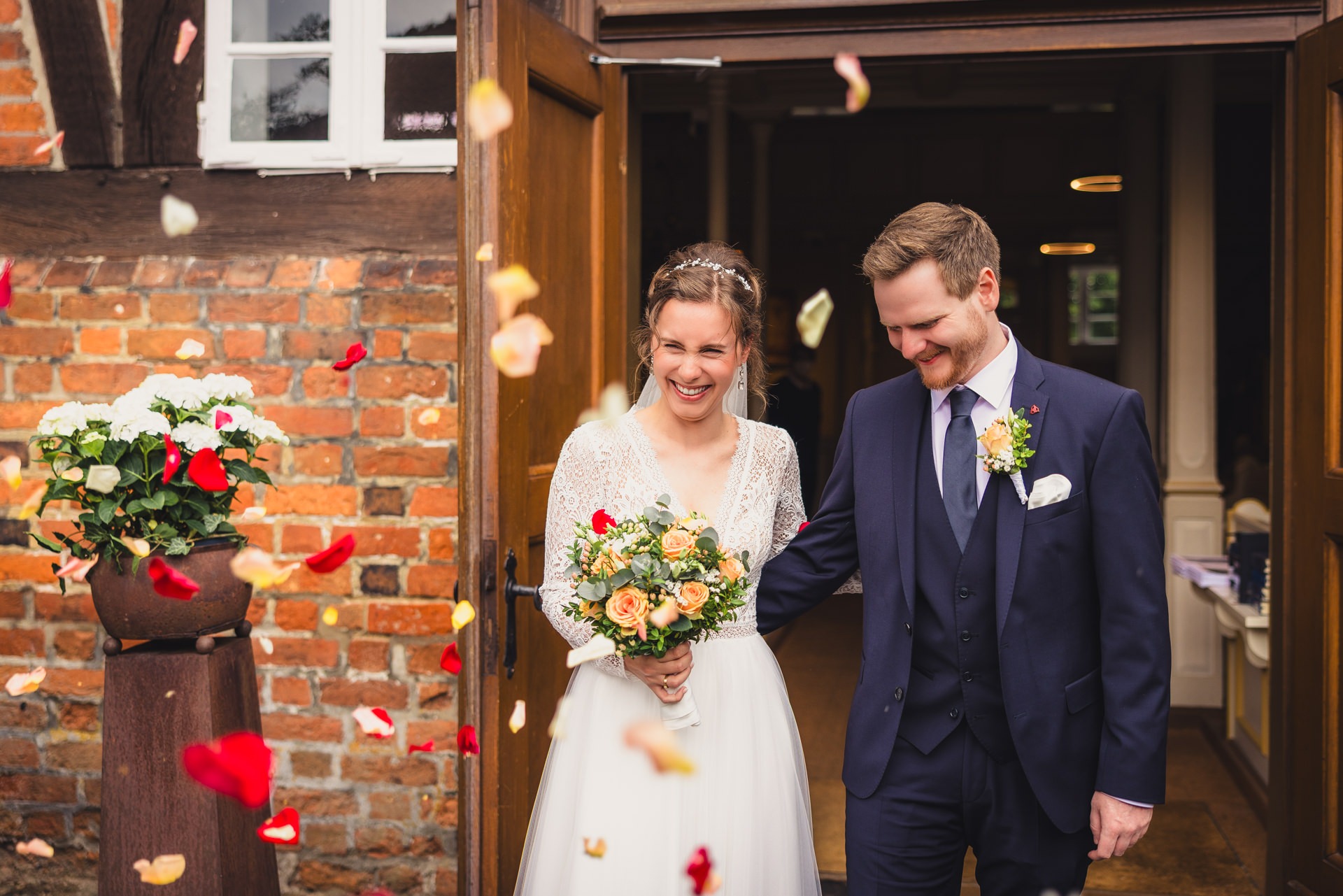 Hochzeitsfotografie Bremen - Brautpaar beim Auszug mit Blütenblättern