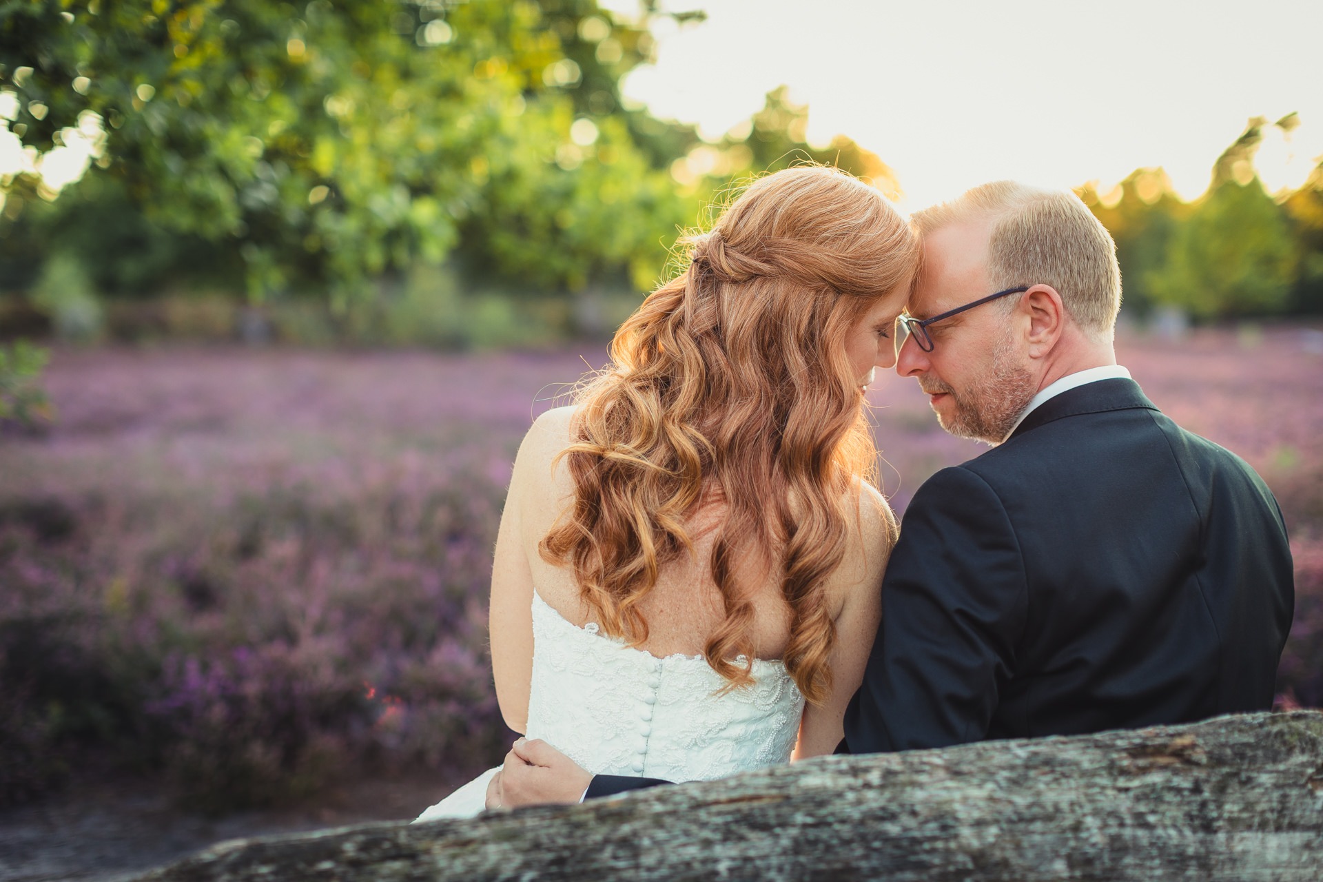 Hochzeitsfotografie Lüneburg - Brautpaar sitzt im Sonnenuntergang in der Heide